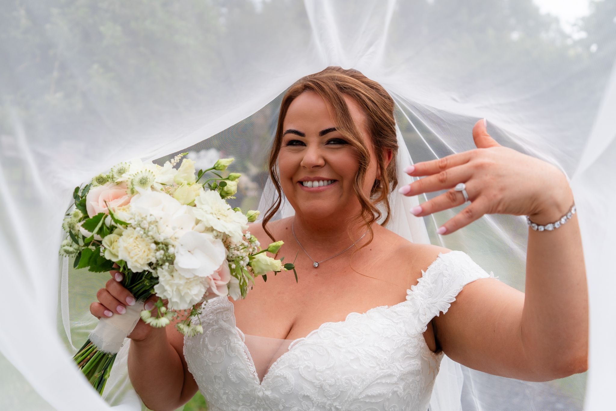 Newlyweds laughing while guests shower them with confetti at the venue exit