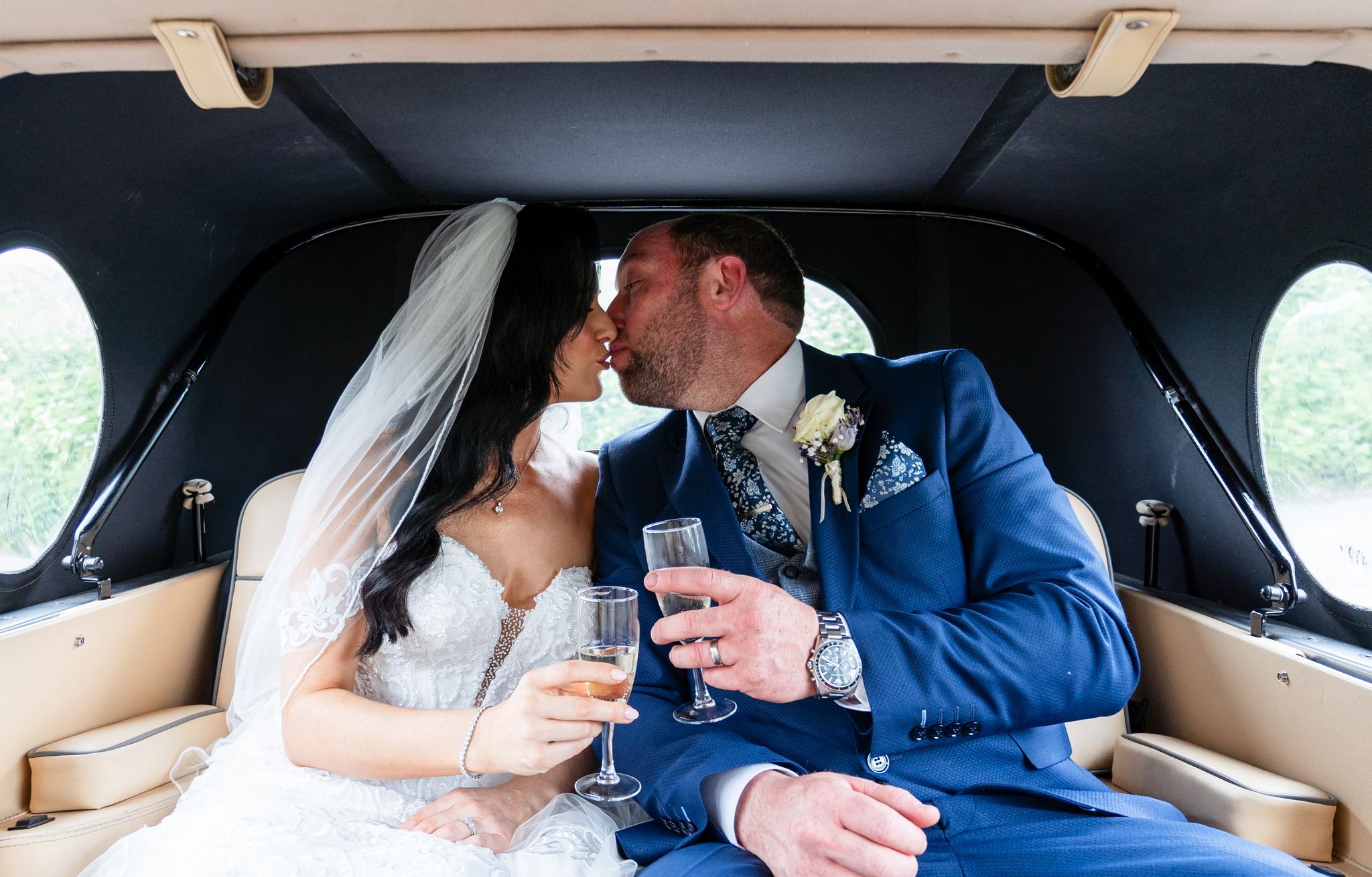 Wedding guests raising glasses during a reception toast under warm string lights