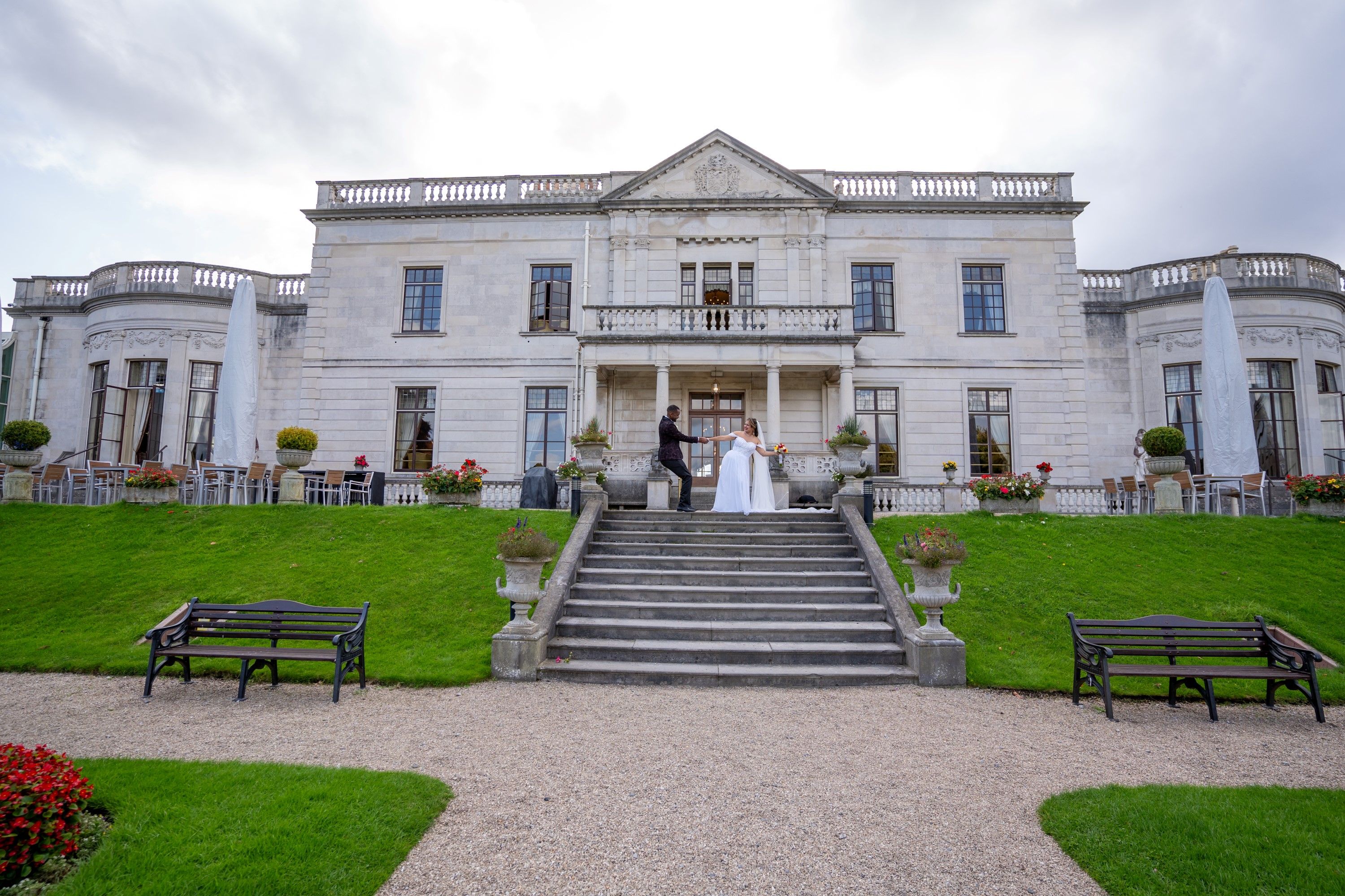 Outdoor garden ceremony with the couple exchanging vows beneath a stone archway